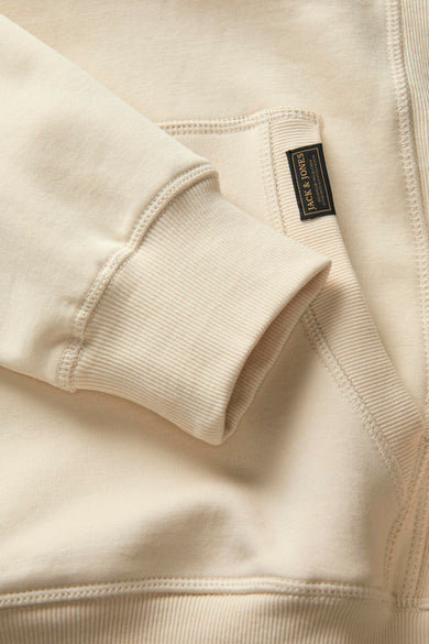 Gilet beige de PREMIUM BLUE par JACK & JONES, avec des bordures de manches côtelées et un étiquette sur la poche.