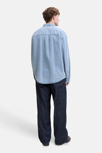 Lichtblauw denim hemd met lange mouwen van ORIGINALS BY JACK & JONES, van achteren gezien, met afgeronde zoom, donkerblauwe jeans en bruine schoenen.