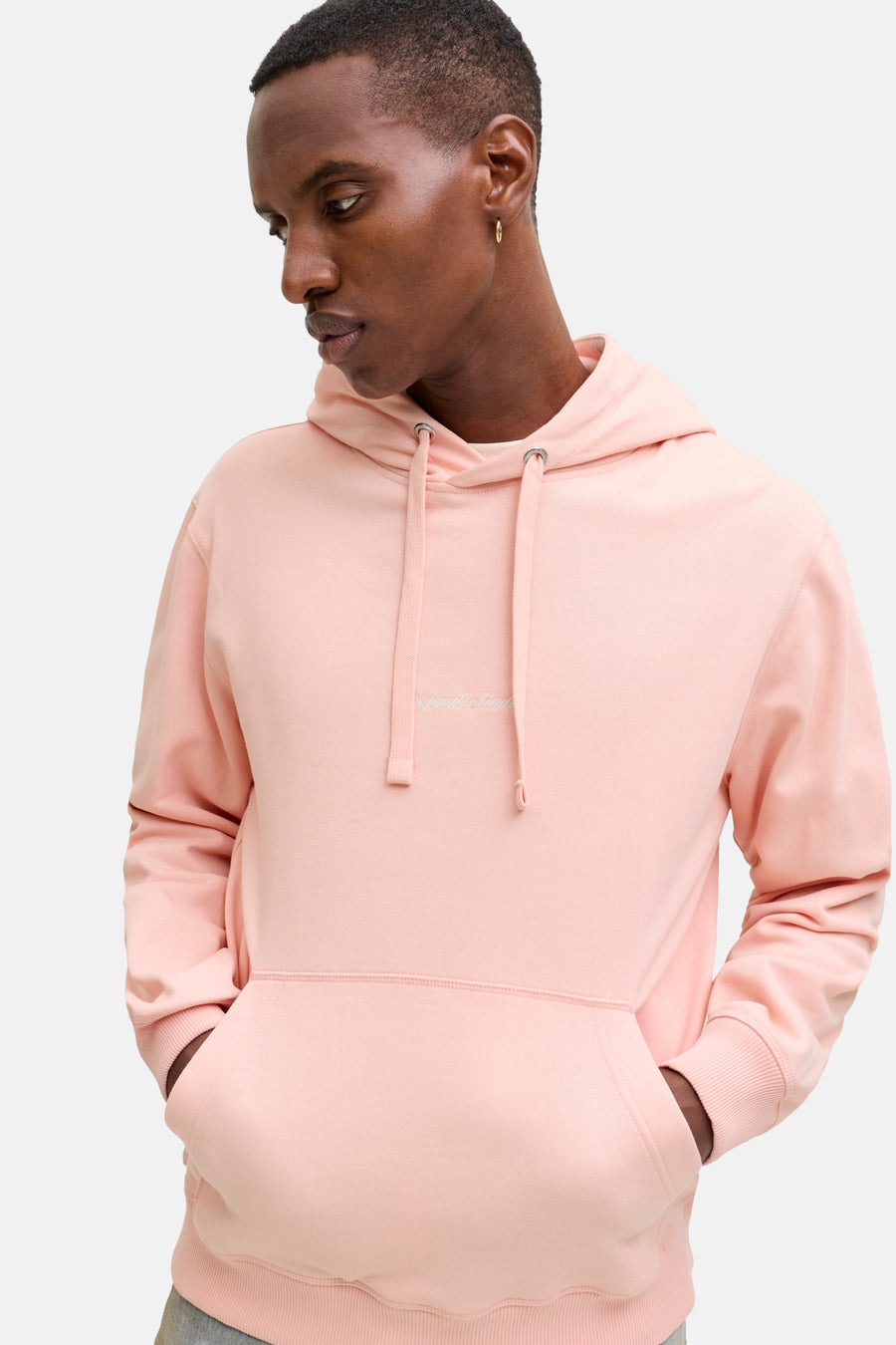 Man in een roze hoodie met capuchon.