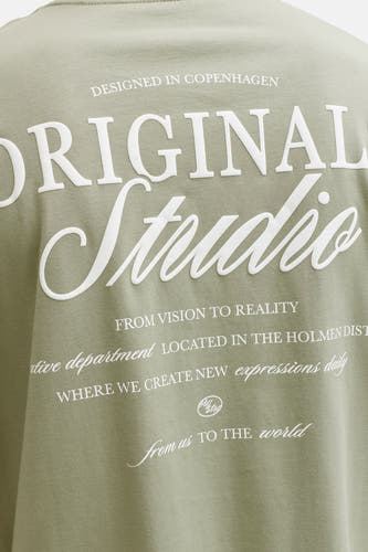 T-shirt vert à manches courtes ORIGINALS BY JACK & JONES, avec texte blanc 'Original Studio' dans le dos.