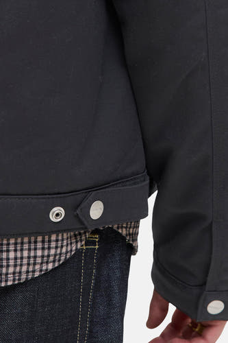 Manteau court noir d'ORIGINALS BY JACK & JONES, avec des boutons pressionnés argentés et une chemise à carreaux visible.