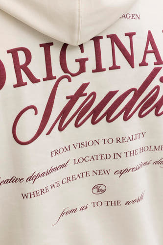 Pull beige à capuche de ORIGINALS BY JACK & JONES, avec de grandes lettres rouges dans le dos.