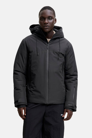 Manteau court et noir de CORE BY JACK & JONES, avec capuche et pantalon noir.