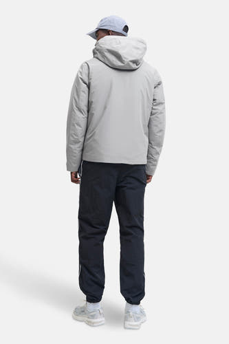 Manteau gris court de CORE BY JACK & JONES, avec capuche, associé à un pantalon foncé et des baskets.