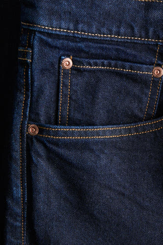 Jean tapered bleu marine de PREMIUM par JACK & JONES, avec un surpiqure doré et un détail de poche.