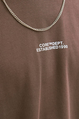 T-shirt brun à manches courtes de CORE BY JACK & JONES, avec une impression de texte blanche et une chaîne d'argent.