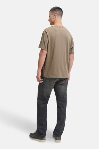 T-shirt Kaki à manches courtes de PREMIUM BLUE par JACK & JONES, vu de dos avec un jean noir et des chaussures grises.