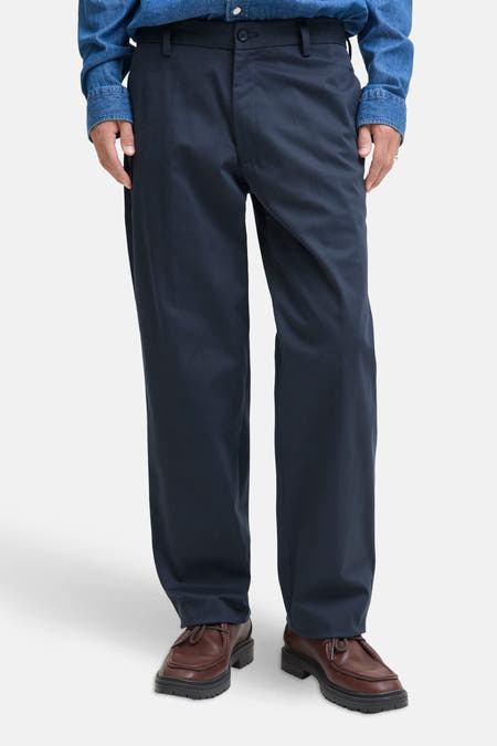 Jean chino bleu de JACK & JONES JEANS INTELLIGENCE, associé à des chaussures marron et une chemise en denim.