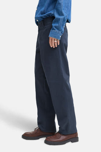 Jean chino bleu de JACK & JONES JEANS INTELLIGENCE, porté avec un chemisier en denim et des chaussures marrons.