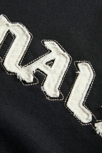 Gilet noir d'ORIGINALS BY JACK & JONES, avec des lettres blanches et des points décoratifs.