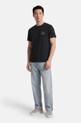 Zwart T-shirt met korte mouwen van CORE BY JACK & JONES, met subtiele print op de borst, gecombineerd met een blauwe jeans.