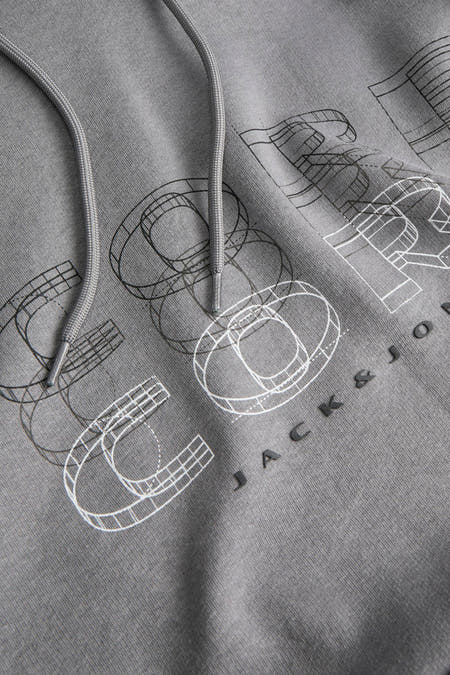 Pull gris à capuche de CORE BY JACK & JONES, avec imprimé graphique et cordon de serrage.
