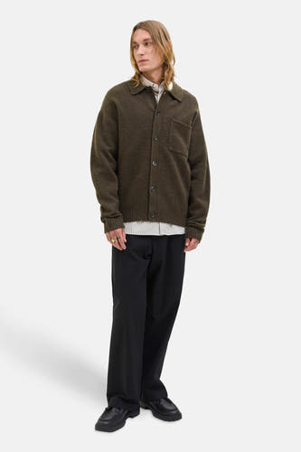 Gilet brun de PREMIUM BLUE par JACK & JONES, avec fermeture à boutons, porté sur un chemisier rayé et un pantalon noir.