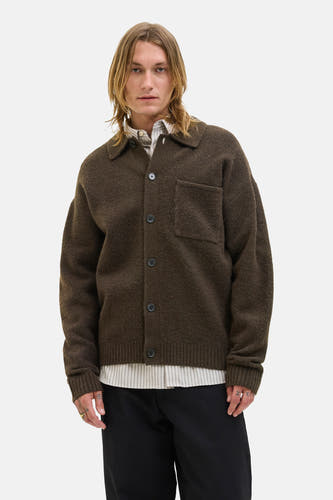 Gilet brun de PREMIUM BLUE par JACK & JONES, avec fermeture à boutons, poche sur la poitrine et porté sur un chemisier rayé.