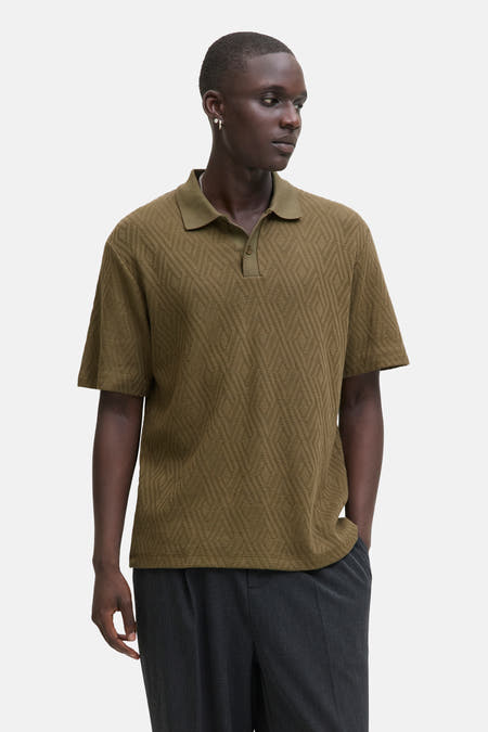 Kaki polo avec des manches courtes de PREMIUM par JACK & JONES, doté d'un motif à carreaux et porté avec un pantalon foncé.