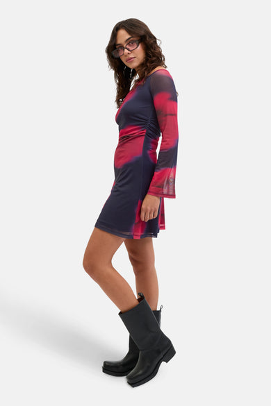 Jupe multicolore à longues manches de JJXX, avec une impression tie-dye abstraite et portée avec des bottes noires.