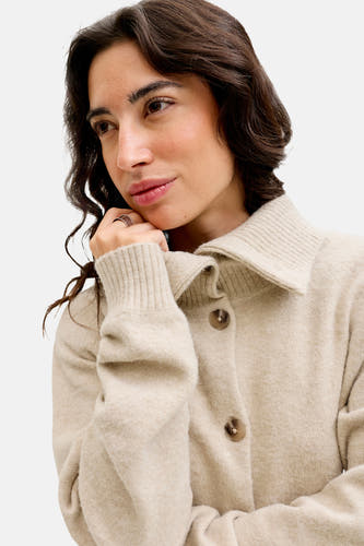 Cardigan beige de JJXX, avec un col et une fermeture à boutons, porté par une femme.