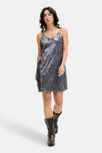 Robe sans manches grise de JJXX, avec paillettes et associée à des bottes brunes.