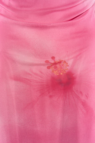 Robe rose de JJXX, confectionnée en tissu mesh semi-transparent avec imprimé hibiscus et décolleté drapé.