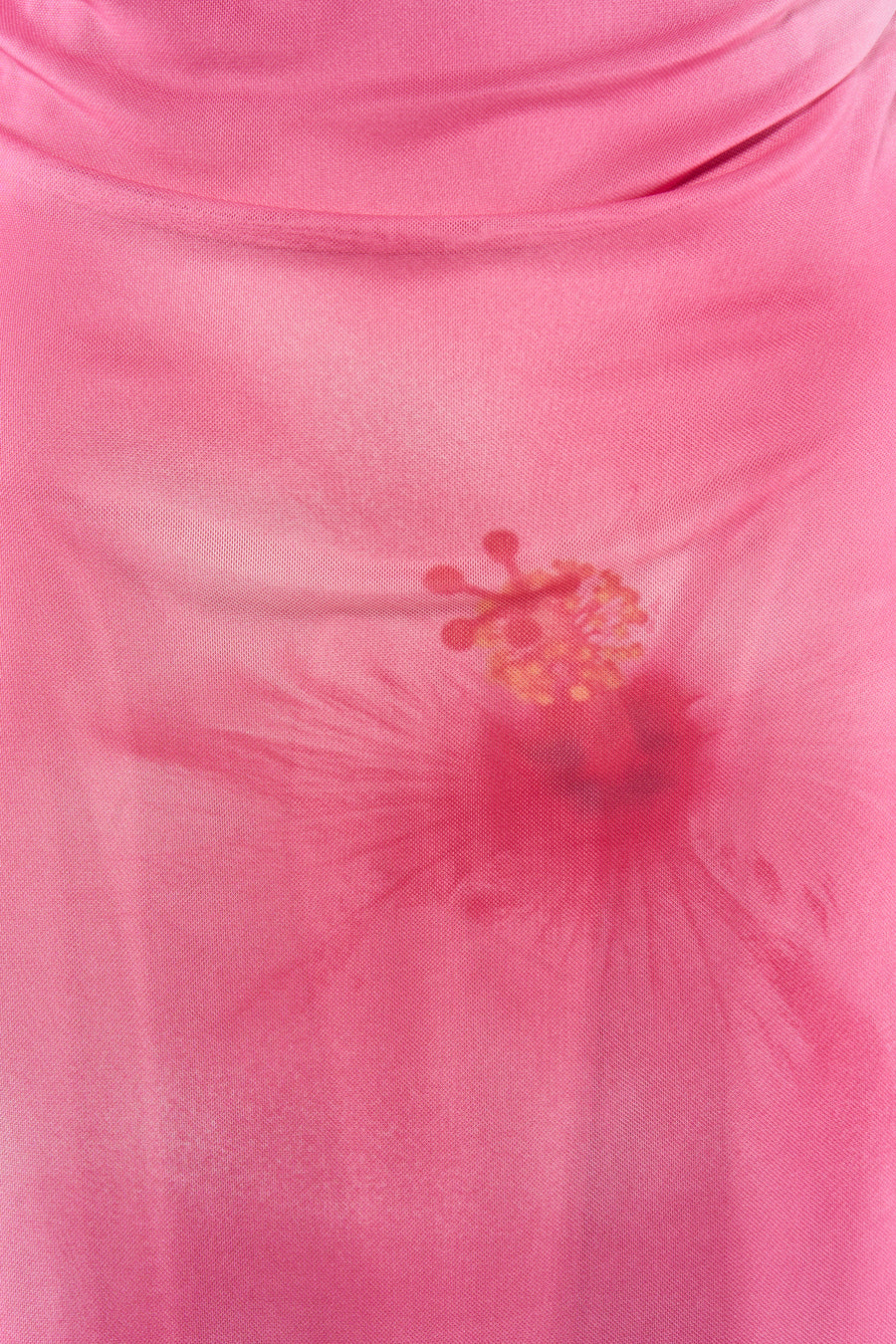 Robe rose de JJXX, confectionnée en tissu mesh semi-transparent avec imprimé hibiscus et décolleté drapé.