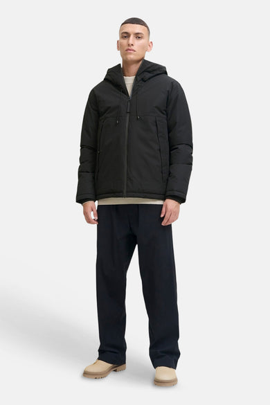 Veste courte matelassée noire de CORE BY JACK & JONES avec capuche et fermeture éclair, portée par un mannequin.