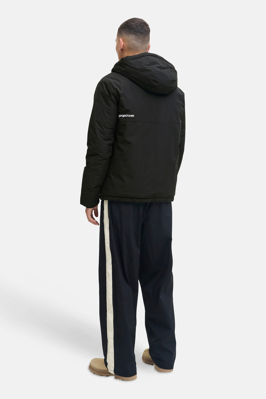 Veste courte noire de CORE BY JACK & JONES avec capuche et 'project core' dans le dos, portée par un homme, vue de dos.