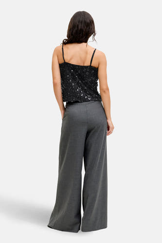 Blouse noire sans manches de JJXX, avec paillettes et associée à un pantalon gris, vue de derrière.