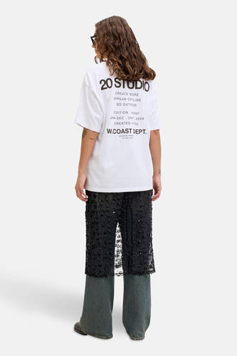 Longue jupe noire de JJXX, à motif floral, associée à un T-shirt blanc et des jeans larges.