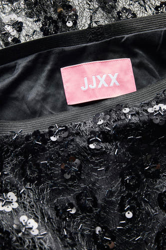 Robe longue noire de JJXX, ornée de volants et de perles, plan rapproché.
