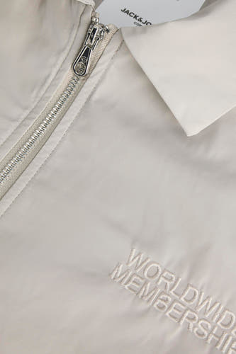 Grijze korte jas van CORE BY JACK & JONES, met zilverkleurige ritssluiting en 'Worldwide Membership'-borduring.