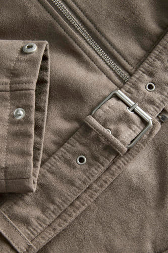 Bruine korte jas van JJXX met ritssluiting, riemgesp en drukknoopdetails in een close-up.
