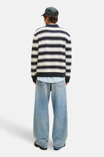 T-shirt bleu d'ORIGINALS BY JACK & JONES, avec des rayures blanches, porté sur un chemisier bleu clair et des jeans larges.