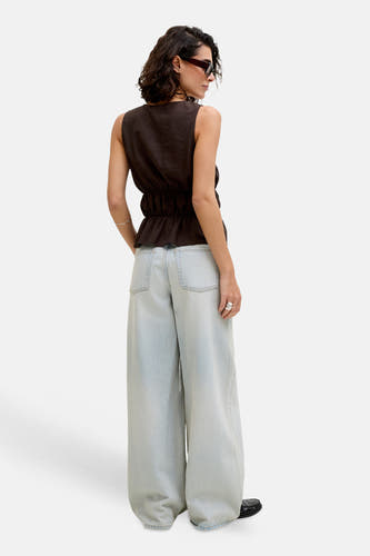 Chemisier sans manches marron de JJXX avec ourlet péplum et taille élastique, associé à un jean ample bleu clair, vu de dos.