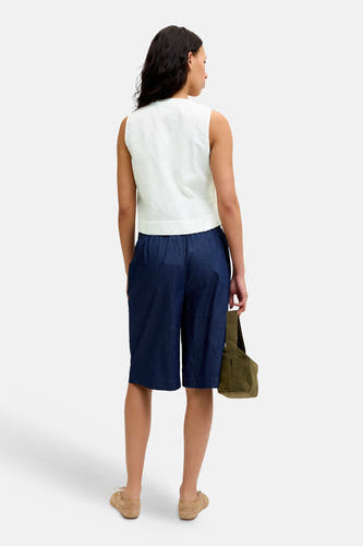 Chemisier blanc sans manches de JJXX avec texture fine, vu de dos, porté avec un short bleu foncé.