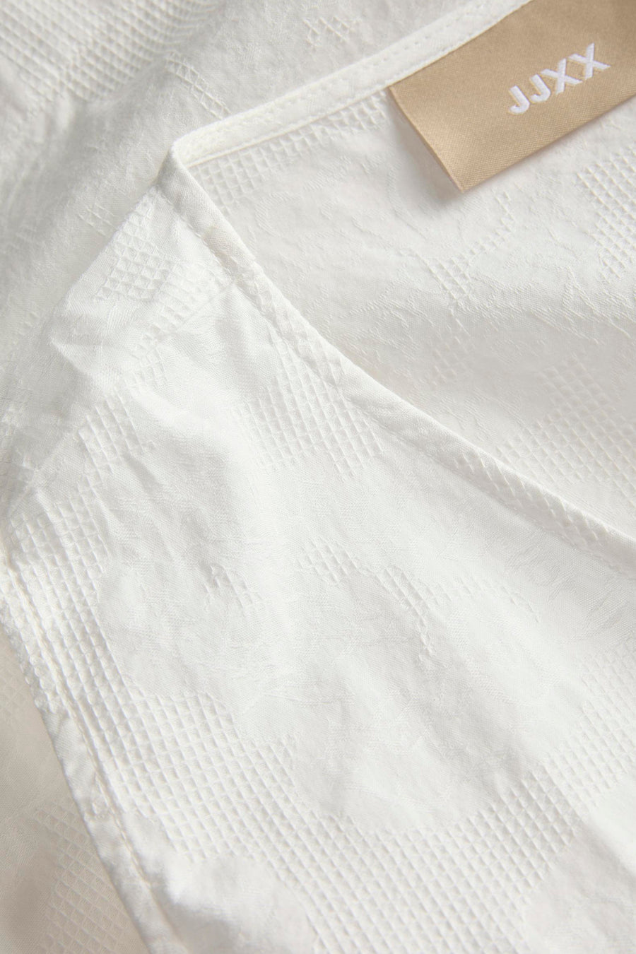 Chemise blanche JJXX avec un motif à carreaux subtil et un détail au niveau de l'encolure.