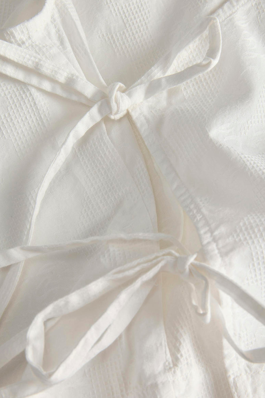 Chemisier blanc JJXX à texture gaufrée et nœuds décoratifs.