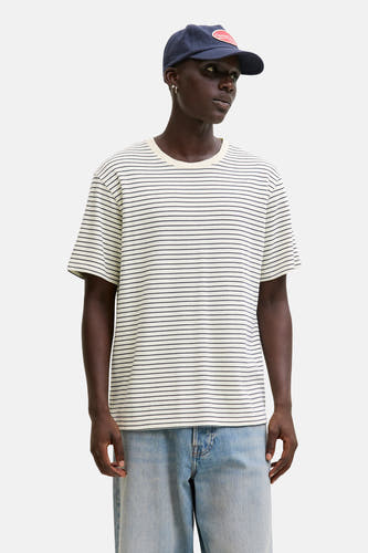 T-shirt beige à manches courtes de ORIGINALS BY JACK & JONES, avec un motif rayé et porté sous une veste kaki.