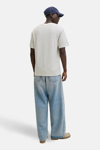 T-shirt beige à manches courtes ORIGINALS BY JACK & JONES, à motif rayé, combiné avec un jean ample et une casquette, vue de dos.