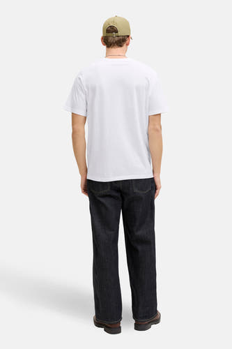 T-shirt blanc à manches courtes de CORE BY JACK & JONES, vu de dos avec un jean foncé et une casquette beige.