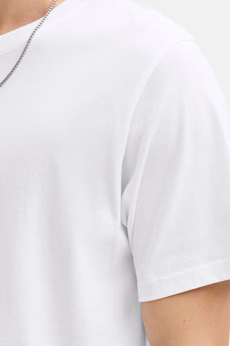 T-shirt blanc à manches courtes de CORE BY JACK & JONES, avec une chaîne argentée autour du cou.