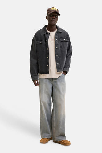 T-shirt beige de ORIGINALS BY JACK & JONES avec un imprimé texte rouge foncé sur la poitrine, porté sous une veste en jean gris foncé.