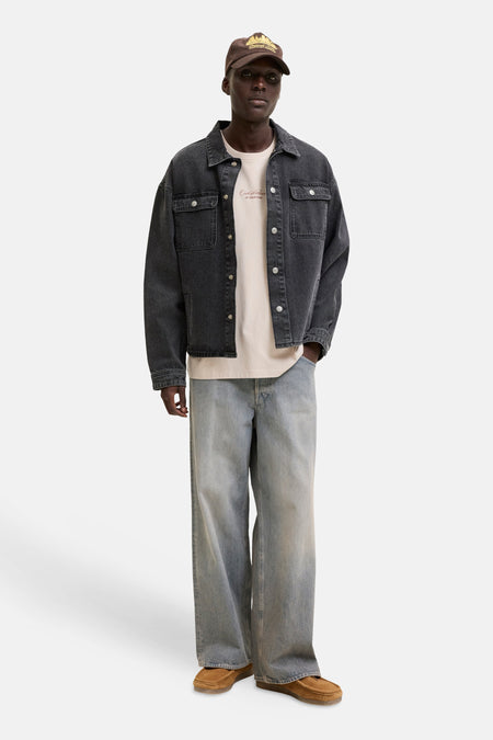 T-shirt beige de ORIGINALS BY JACK & JONES avec un imprimé texte rouge foncé sur la poitrine, porté sous une veste en jean gris foncé.