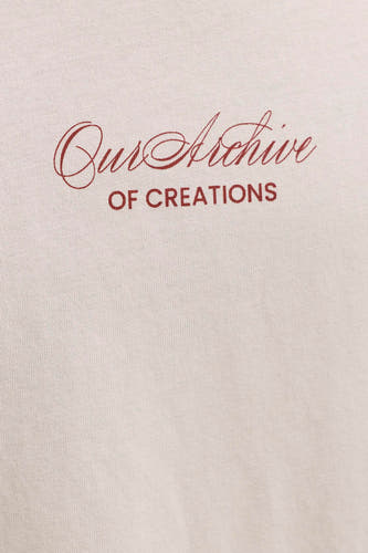 T-shirt beige de ORIGINALS BY JACK & JONES avec texte rouge 'Our Archive OF CREATIONS' sur un tissu tricoté.