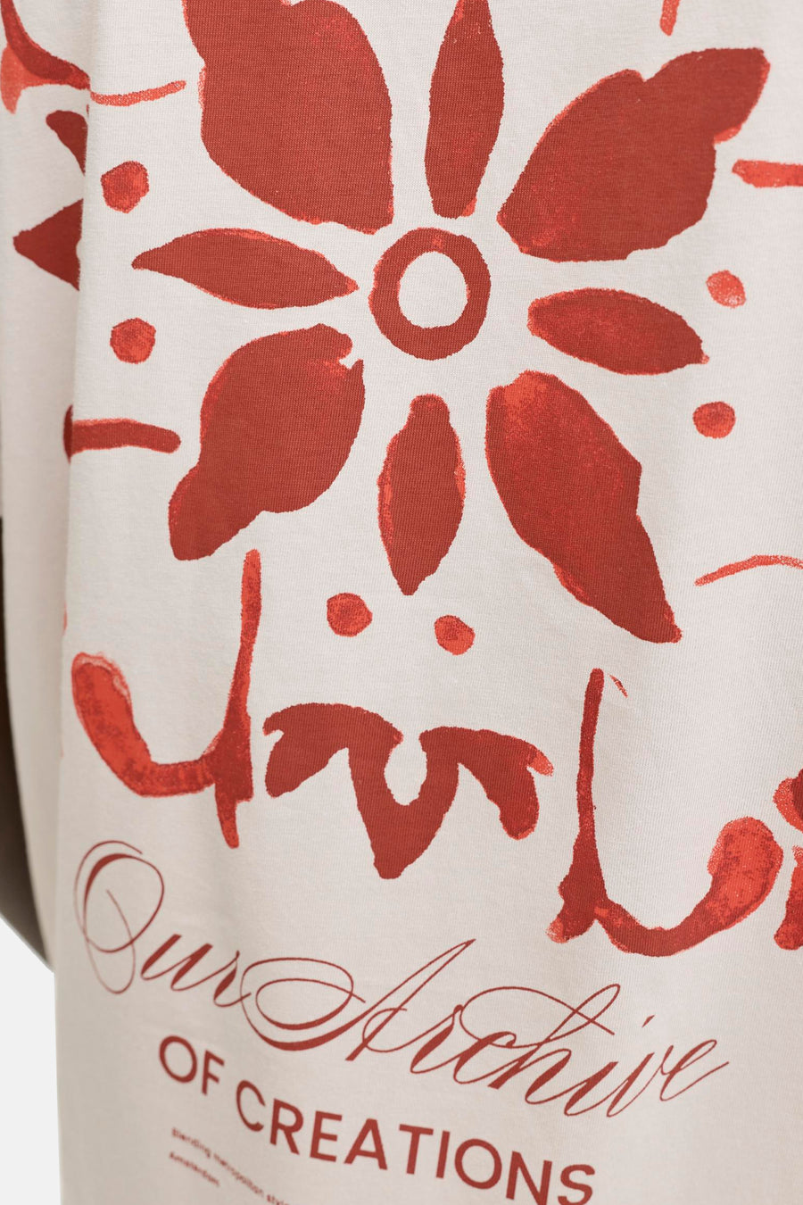 T-shirt beige de ORIGINALS BY JACK & JONES avec un imprimé floral marron rouille et le texte 'Our Archive OF CREATIONS'.