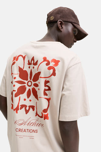 T-shirt beige de ORIGINALS BY JACK & JONES, vu de dos, avec un grand imprimé floral rouge et du texte dans le dos.