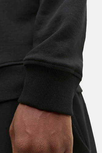 Gilet noir de CORE BY JACK & JONES, détail rapproché des manches côtelées et de la texture du tissu.