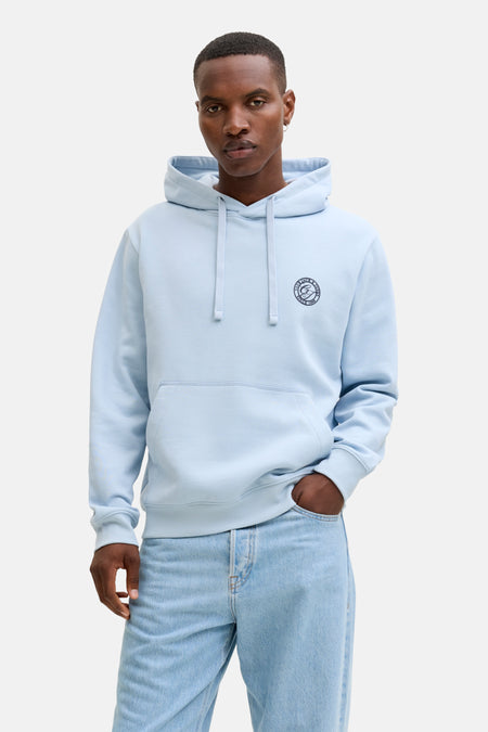 Man in lichtblauwe hoodie en jeans.