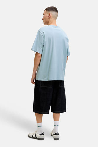 T-shirt ample bleu de ORIGINALS BY JACK & JONES, dos d'un mannequin portant un short foncé et des baskets.