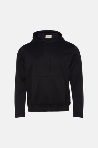 Pull-over noir avec capuche de CORE BY JACK & JONES, dos, associé à des jeans bleus et des baskets blanches.