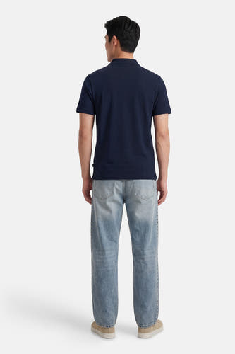 Polo bleue de ORIGINALS BY JACK & JONES, vue de dos, portée avec un jean bleu clair à clous et des baskets beiges.